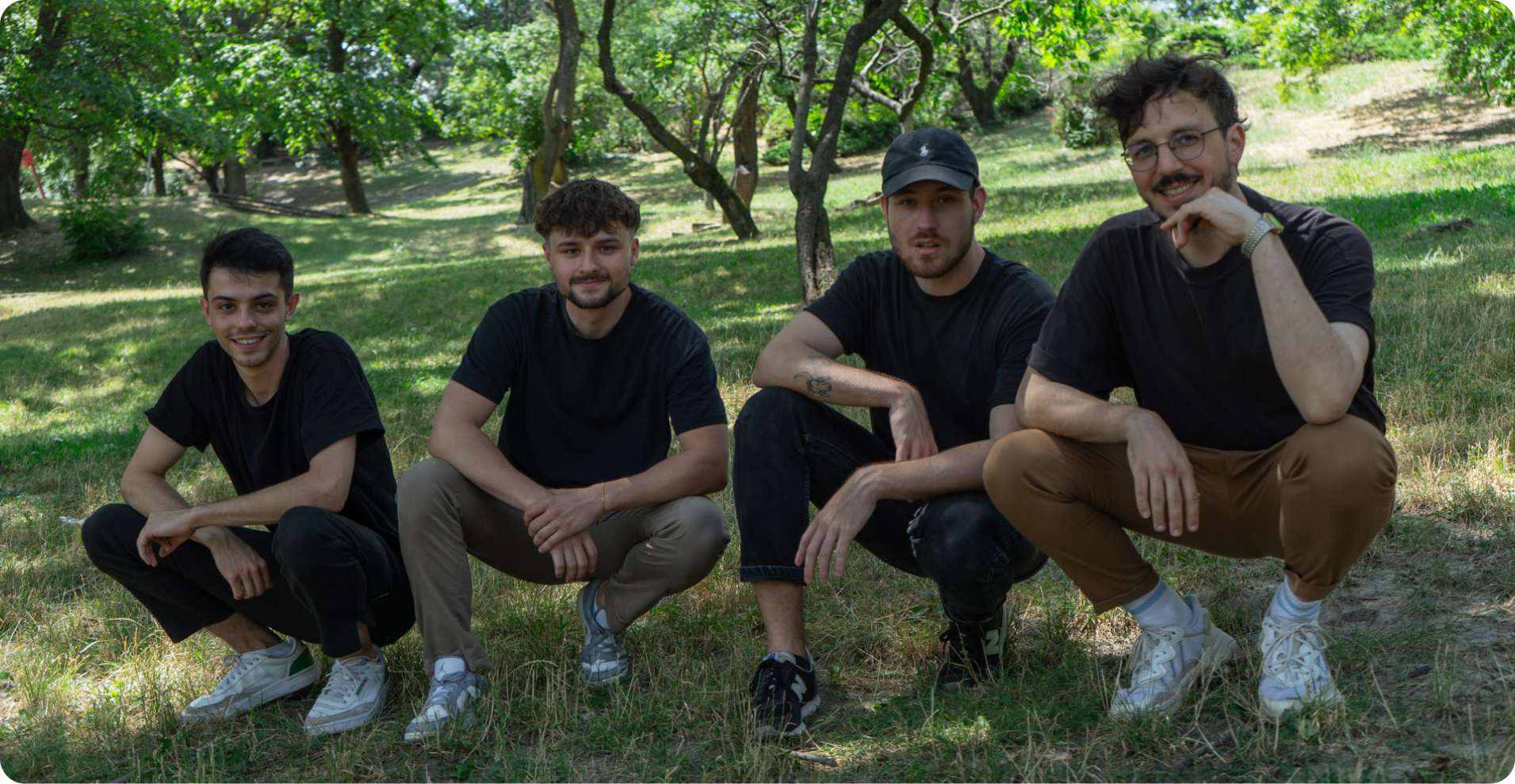 Four of the Once Advertisements employees, Matyas Laneury, Gergo Mezes, Krisztian Mezei, and Kristof Menesi sitting on the field at ‘Gellért Hill’ in Hungary.