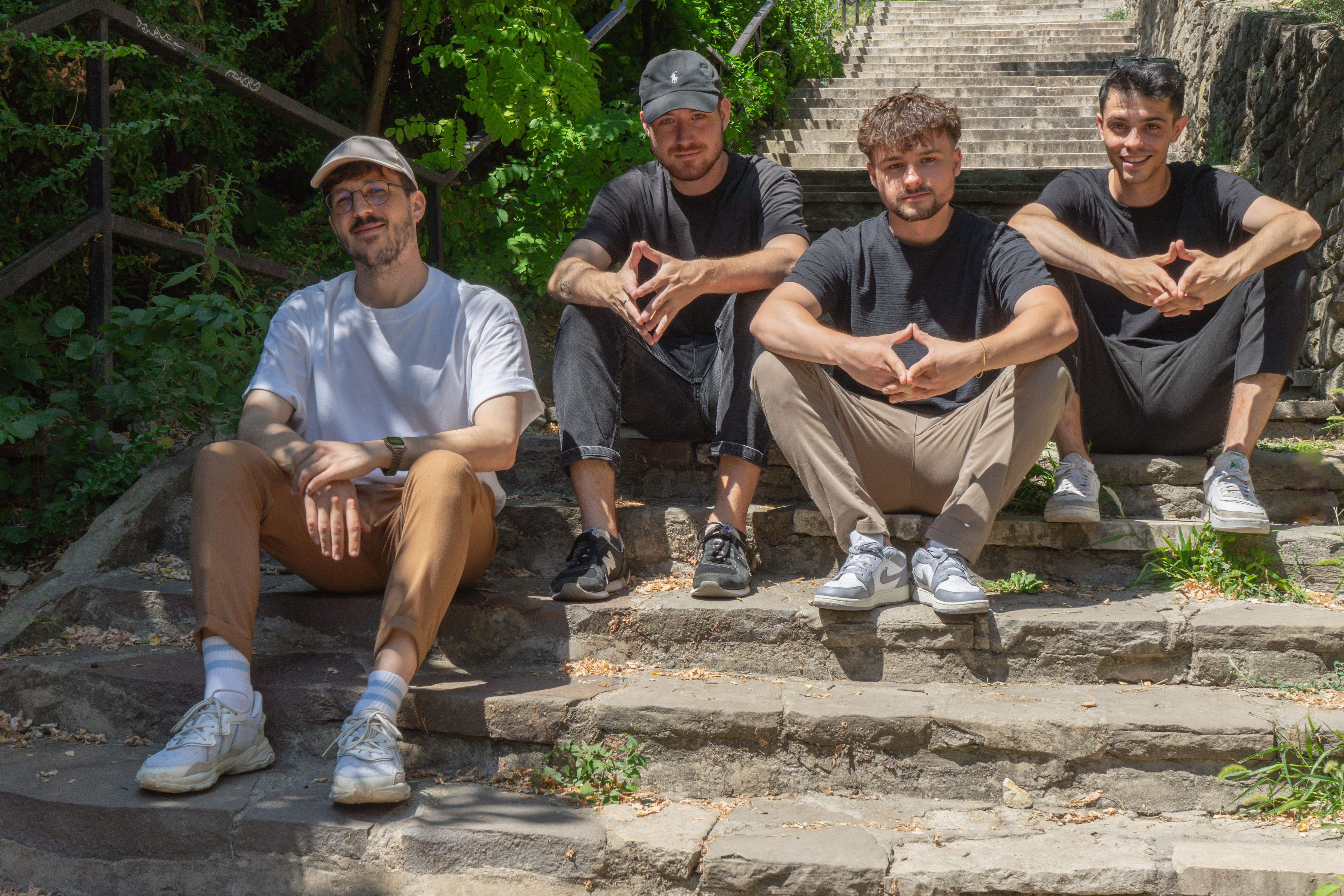 Four of the Once Advertisements employees, Matyas Laneury, Gergo Mezes, Krisztian Mezei, and Kristof Menesi sitting on the stairs at ‘Gellért Hill’ in Hungary.
